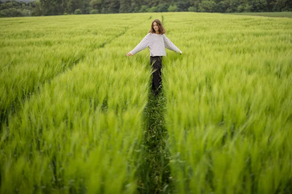 Femme détendue debout dans un champ vert et jouit d'une nature calme — Photo