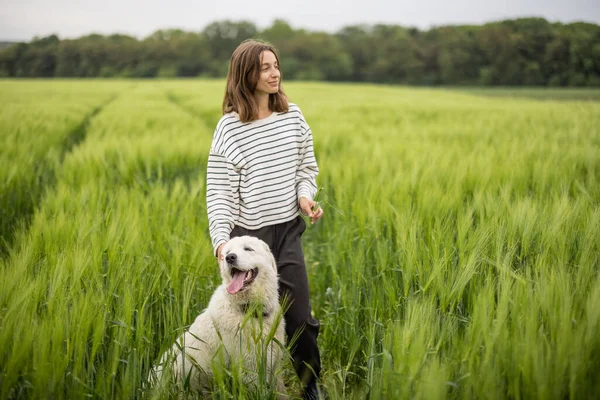 Ontspannen vrouw staat in het groene veld en geniet van kalme natuur — Stockfoto