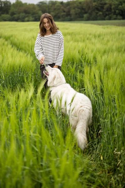 Avslappnad kvinna står i grönt fält och njuter av lugn natur — Stockfoto
