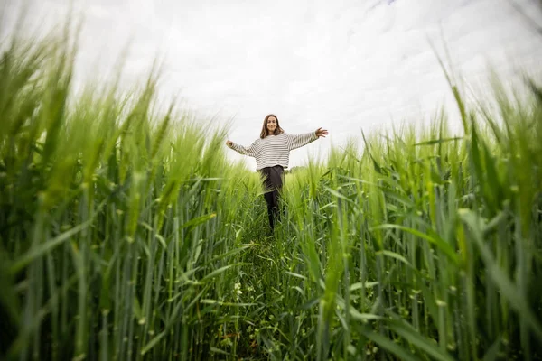 Femme détendue debout dans un champ vert et jouit d'une nature calme — Photo