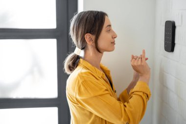 Kadın evdeki alarm klavyesine bir kod giriyor