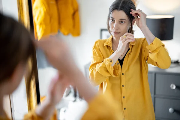 Frau blickt in den Spiegel und macht sich bereit, rauszugehen — Stockfoto