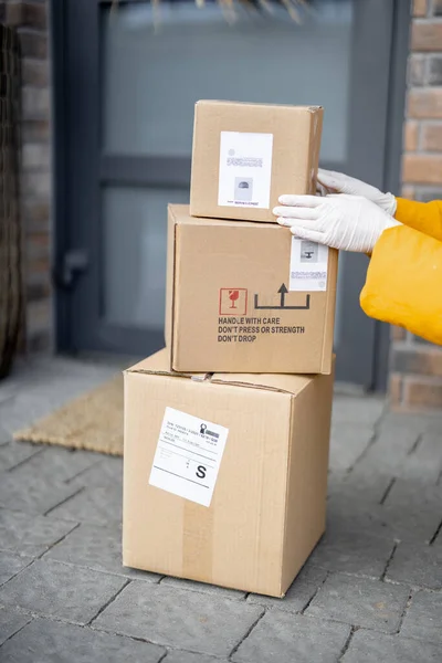 Courier met des colis sur le porche devant la porte d'entrée, — Photo