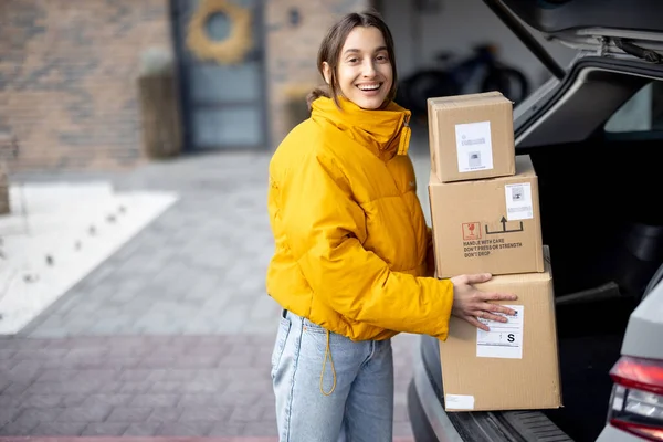 Woman arrives home with parcels