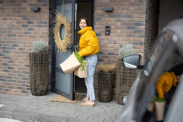 Mujer llega a casa con bolsas llenas de alimentos frescos — Foto de Stock