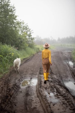 Sarı lastik çizmeli kadın çiftçi. 