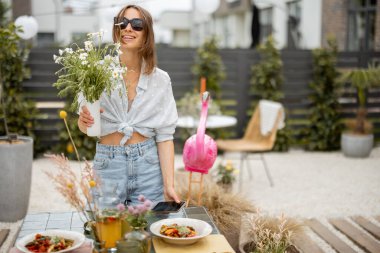 Dışarıda yemek masasını dekore eden kadın.