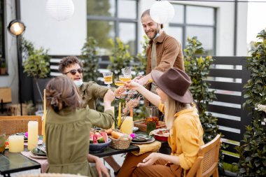 Arkadaşların yazın arka bahçede yemek yiyor.