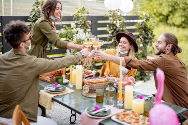 Arkadaşların yazın arka bahçede yemek yiyor.