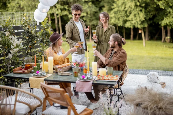 Jeunes amis dînant dans la cour de la maison de campagne dans la nature — Photo