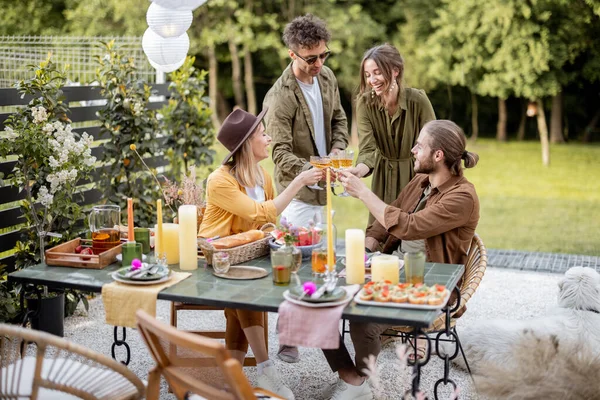 Genç arkadaşlar doğadaki kır evinin arka bahçesinde yemek yiyorlar. — Stok fotoğraf