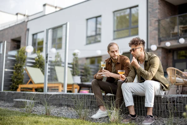 Twee mannelijke vrienden praten op een veranda van het landhuis — Stockfoto