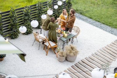 İnsanların yemek yediği güzel bir arka bahçenin manzarası.