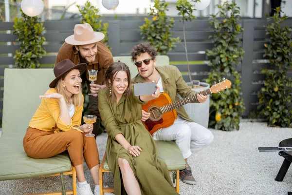 Amici con drink e chitarra si divertono in cortile, chiamando al telefono — Foto Stock