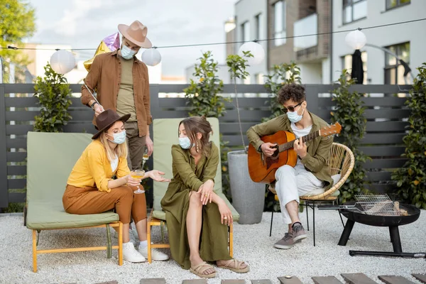 Amigos en mascarilla celebrando al aire libre — Foto de Stock