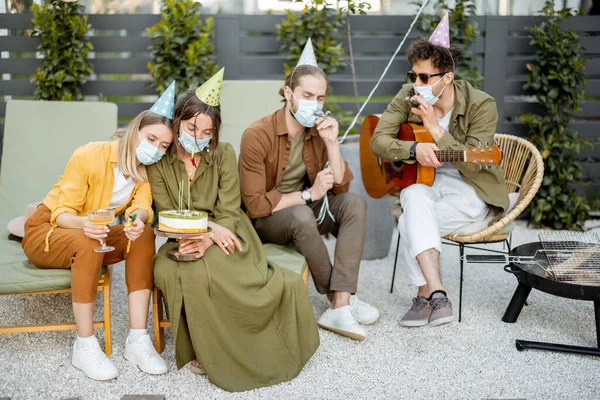 Amis dans le masque de visage célébrant anniversaire en plein air — Photo