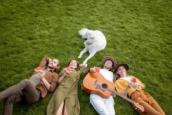 Freunde liegen zusammen auf dem grünen Rasen — Stockfoto