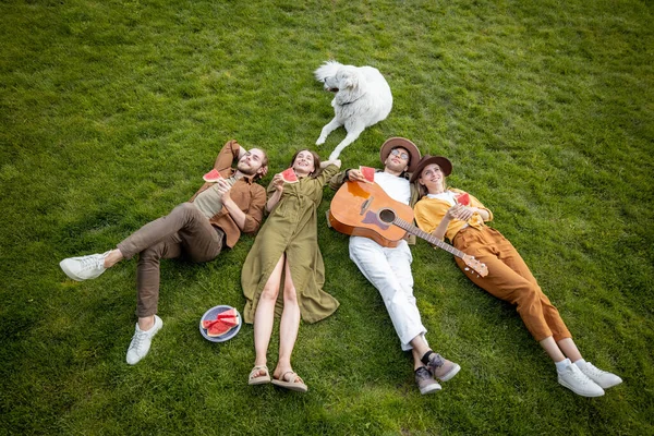 Freunde liegen zusammen auf dem grünen Rasen — Stockfoto