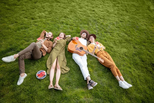 Amis couchés ensemble sur la pelouse verte — Photo