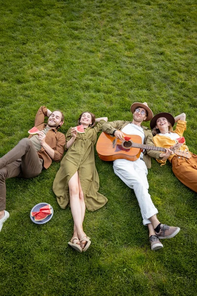 Amis couchés ensemble sur la pelouse verte — Photo