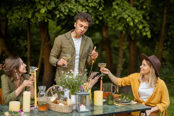 Vänner som äter en festlig middag i naturen — Stockfoto