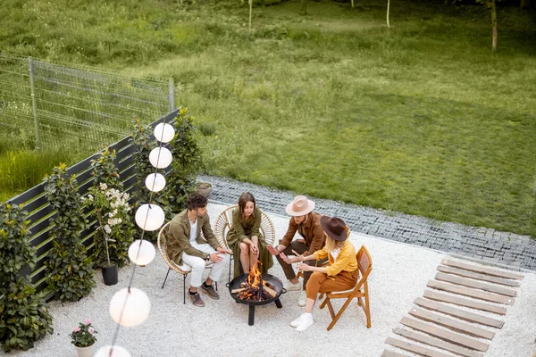 Güzel bir arka bahçenin manzarası şöminenin yanında oturan insanlarla dolu. — Stok fotoğraf