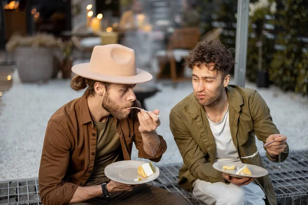 Zwei männliche Freunde unterhalten sich auf einer Veranda des Landhauses — Stockfoto