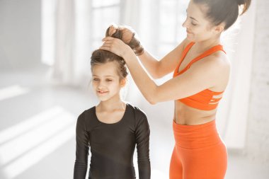 Annem spor yaparken kızına bir saç stili yapıyor.