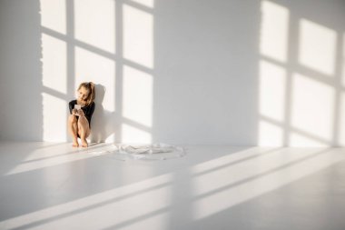 Jimnastik sınıfında akıllı telefonuyla oturan küçük kız.