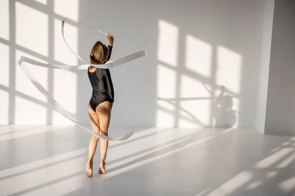 Niña practicando gimnasia rítmica con una cinta — Foto de Stock