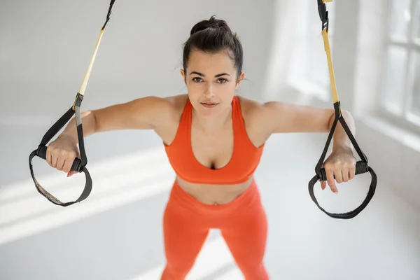 Deportiva haciendo flexiones en correas TRX — Foto de Stock