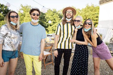 Yüzü maskeli arkadaşlar parti için toplanıyor.