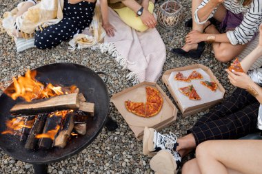 Dostlar ateşle dolu kasenin yanında