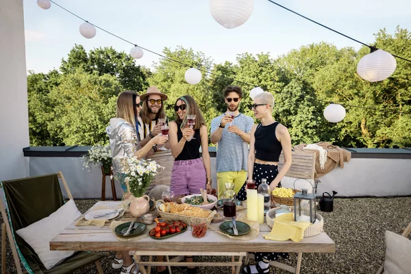 Unga eleganta vänner som har en festlig middag på takterrassen — Stockfoto