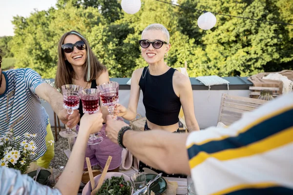 Unga eleganta vänner som har en festlig middag på takterrassen — Stockfoto