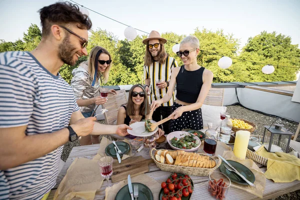 Amigos compartiendo comida en la cena al aire libre — Foto de Stock