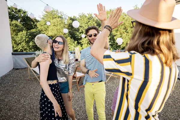 Jóvenes amigos elegantes saludan en la fiesta al aire libre — Foto de Stock