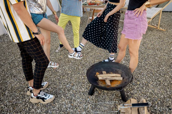 Freunde grüßen mit Füßen, versammeln sich auf einem Party-Außengelände — Stockfoto