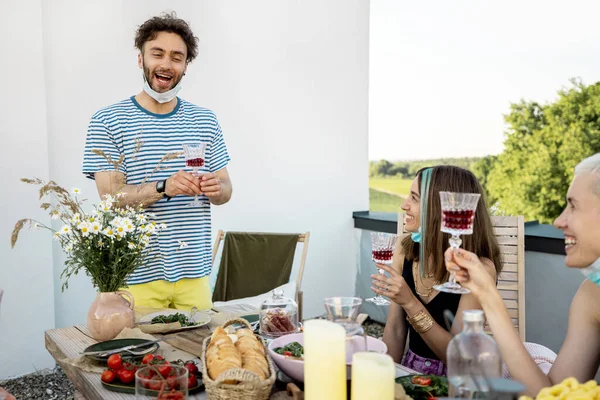 Vänner i ansiktsmasker har en festlig middag utomhus — Stockfoto