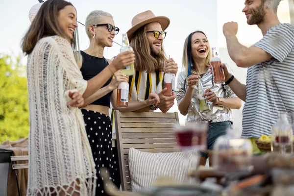 Jonge stijlvolle vrienden met een feestelijk diner op het dakterras — Stockfoto