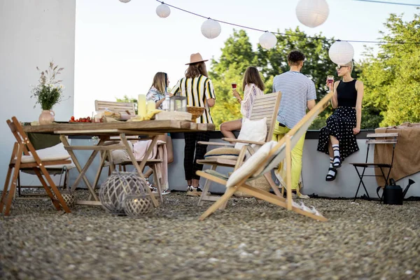 Jovens amigos elegantes tendo um jantar festivo no terraço do telhado — Fotografia de Stock