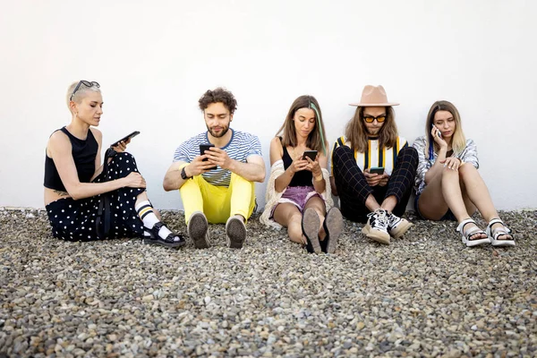 Akıllı telefonlu arkadaşlar sırada oturuyorlar. — Stok fotoğraf