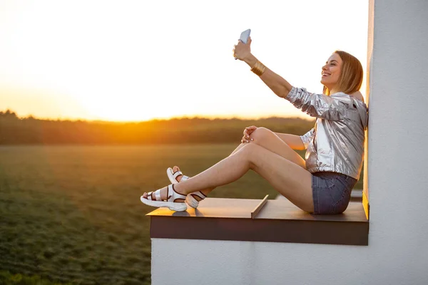 Mujer disfrutar de la vista del atardecer en la azotea —  Fotos de Stock