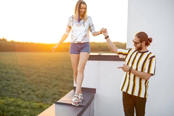 Couple walk on the rooftop at sunset — Stock Photo, Image