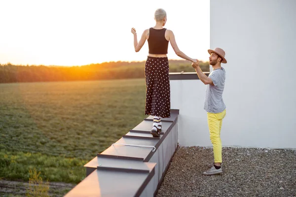 Couple walk on the rooftop at sunset — Stock Photo, Image