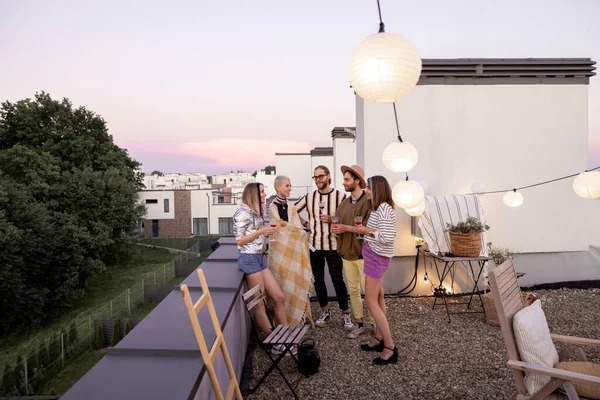 Vrienden hebben plezier op een feestje op het dak in de schemering — Stockfoto