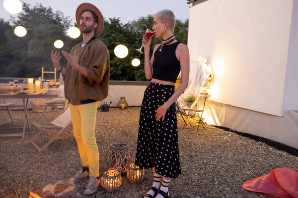 Amigos junto a una chimenea en la azotea al atardecer — Foto de Stock