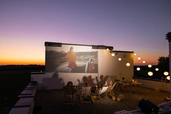 Οι άνθρωποι βλέπουν ταινία στη βεράντα του τελευταίου ορόφου το ηλιοβασίλεμα — Φωτογραφία Αρχείου