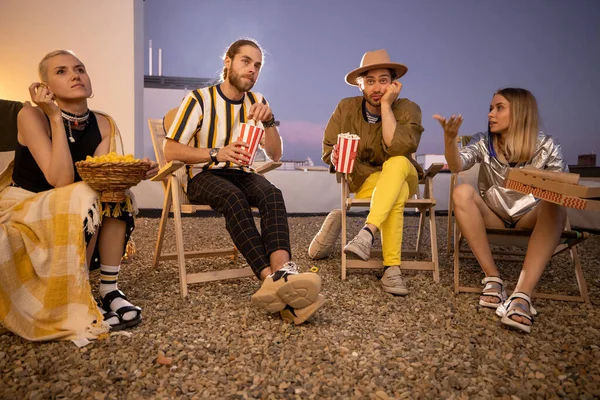 Young people watching football match or film outdoors — Stock Photo, Image