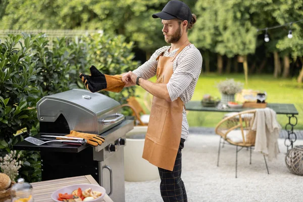 Snygg man förbereder sig för matlagning på grill — Stockfoto